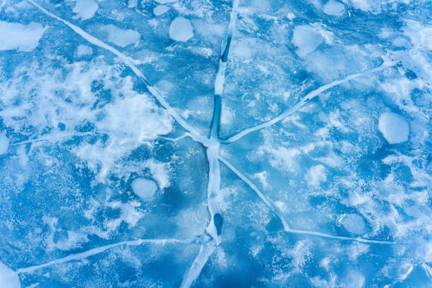 istock Cracked frozen lake with snow covered on winter 2163210413