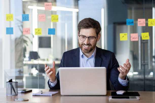 istock Businessman having video call in modern office with sticky notes and gadgets 2163214714