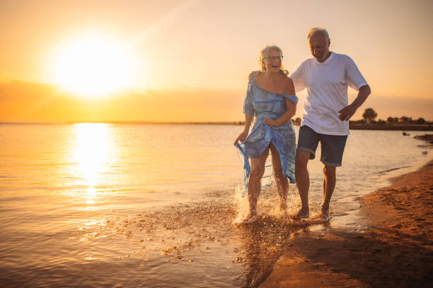 istock Couple running along the beach at sunset, joyful moment 2163215314