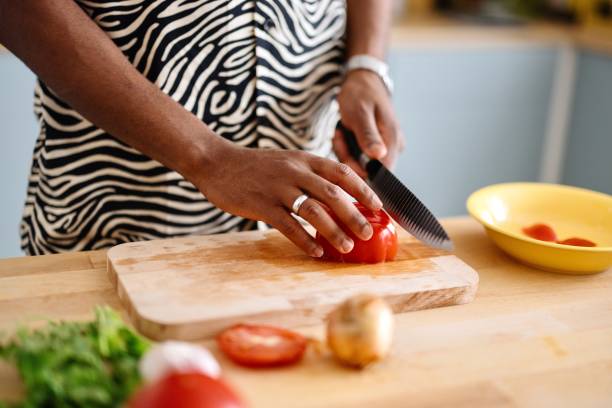 istock Close-up of a man cutting tomatoes in the kitchen 2163216017