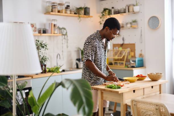 istock Side view of a man preparing lunch in the kitchen 2163216063