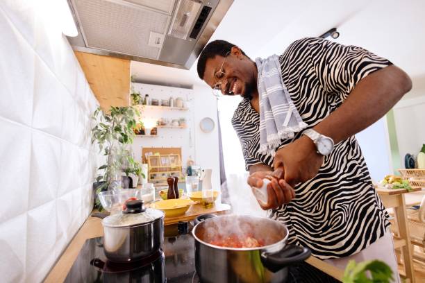 istock Side view of a smiling man cooking in his kitchen 2163216141