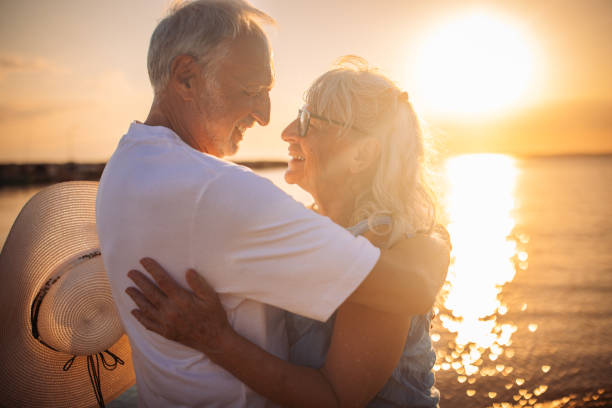 istock Elderly couple embracing on the beach at sunset. 2163216876