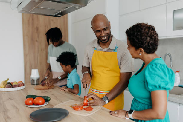 istock Father smiling while cutting vegetables with family 2163217693