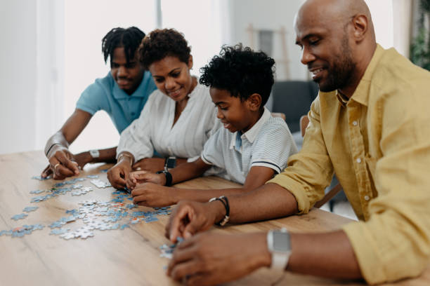 istock Family engaged in a puzzle activity at the kitchen table. 2163220723