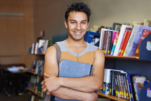 istock Portrait, arms crossed or happy man in library for education or development for future growth. Scholarship, knowledge or male student with smile or books for studying or learning in college campus 2163220762