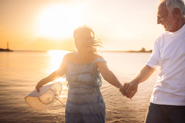 istock Elderly woman holding hands with partner on the beach 2163222171