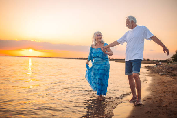 istock Joyful couple holding hands beachside at sunset walk 2163223311