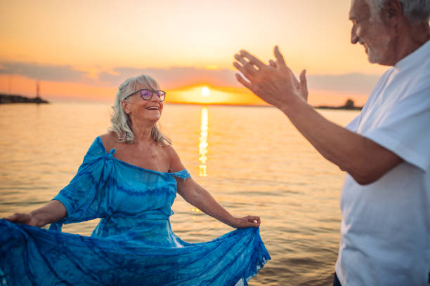 istock Joyful elderly couple on the beach at sunset 2163223625