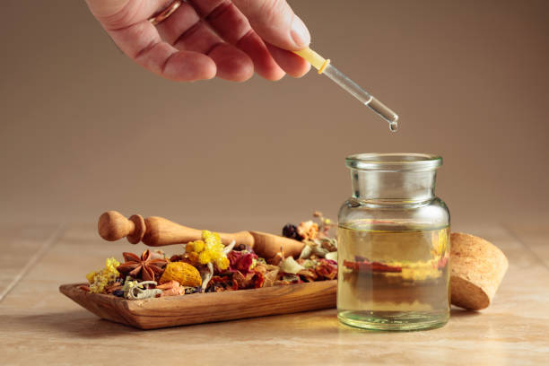 istock Dropping essential oil or herbal tincture into a glass bottle. 2163224079