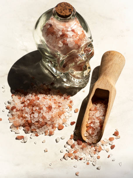 istock Pink Himalayan salt, an important nutritional element, full of minerals, magnesium. Skull-shaped bottle: the benefits or harms of salt. Eco style, sunlight, white background 2163224903