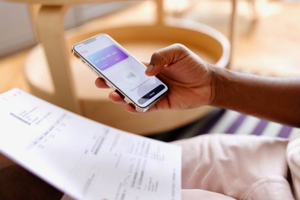 istock Close-up of a man using a baking app on his smartphone 2163225691