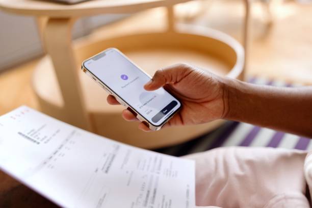 istock Close-up of an unrecognizable man using online banking on his smartphone 2163225700