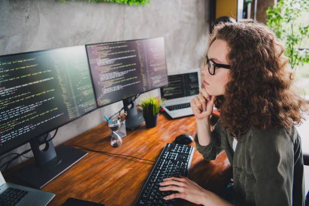 istock Photo of successful woman coder hacker web creator sitting armchair comfortable workspace workstation indoors 2163226052