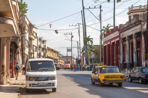 Havana, Cuba - May 12, 2024: An old Lada taxi drives on a city street by weathered old buildings. City life