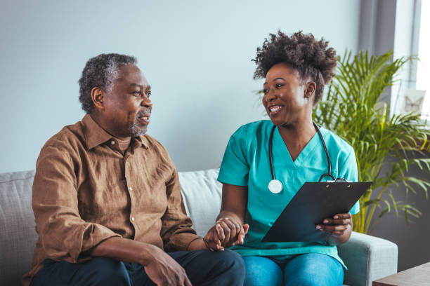 istock Caring Nurse at Home Visit Assisting Senior Patient 2163227289