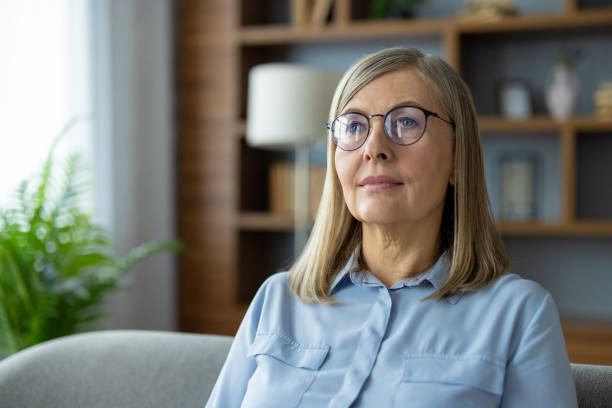 istock Middle-aged woman with glasses thinking deeply in a cozy home setting 2163233709