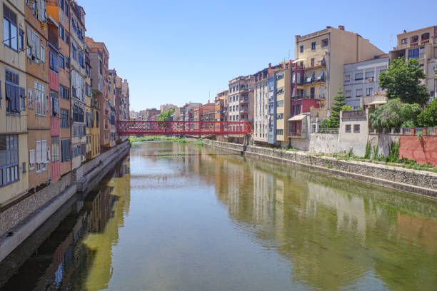 The tower of Girona Cathedral rises above the colorful residential buildings in the old town, Girona, Spain
