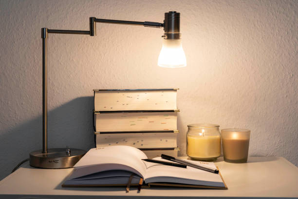 istock A cozy study desk with books, notebooks, and journals arranged neatly alongside candles, pens, pencils, and a desk lamp, creating an inviting atmosphere for learning and reading. 2163240863