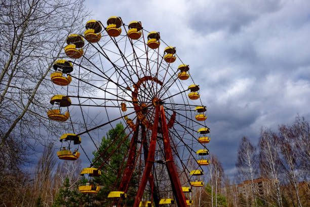 istock A Ferris wheel with yellow cabins against a cloudy sky. 2163241169