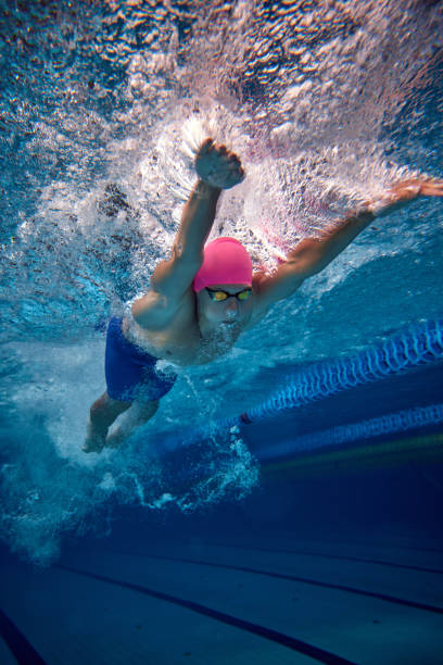 istock Male swimmer, highlighting his efficient freestyle technique, wearing blue trunks and goggles in pool underwater. 2163243997