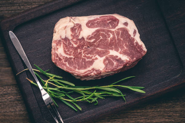 Steak marinating on wooden tray rosemary macrophotography