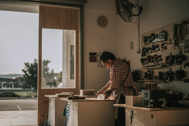 asian chinese senior carpenter working in woodshop workshop