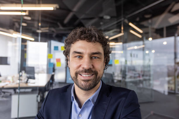 istock Businessman on video call looking at camera in modern office setting 2163253453