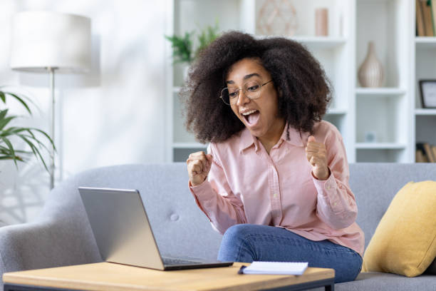 istock Excited woman celebrating success while working on laptop at home 2163258201