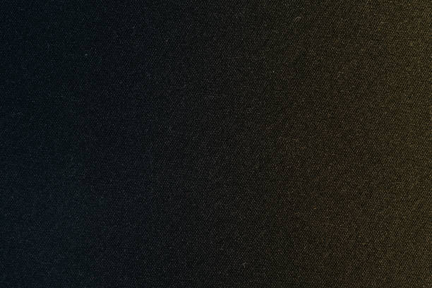 istock dark black texture background fabric material background wallpaper surface with slightly gradient of blue and yellow colors 2163259424