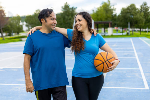 istock Hispanic couples happy and healthy practicing basketball 2163262559