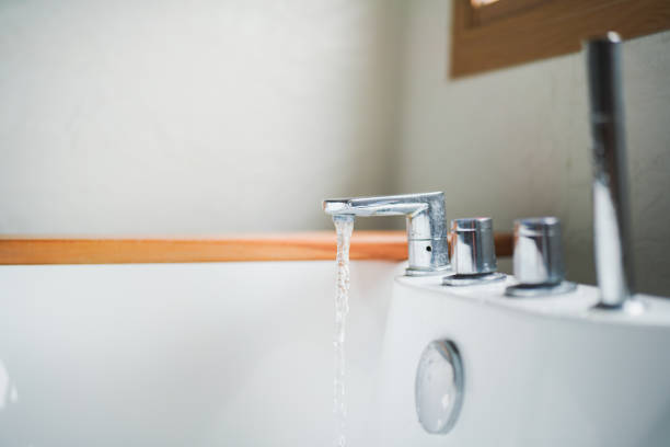 Water pouring into bathtub making bubbles.
