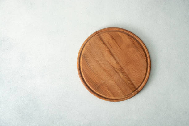 istock Round wooden cutting board on a light background.Top view. Copy space. 2163266716