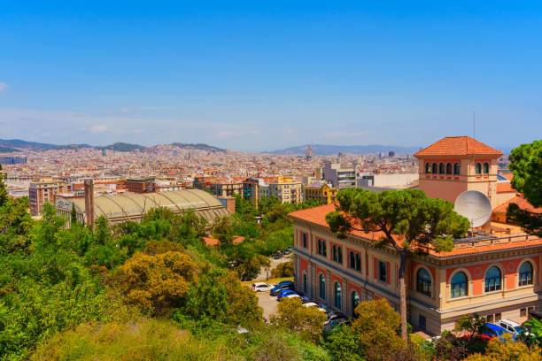 Barcelona, Spain - July 16, 2024: Scenic view of Barcelona taken from a hillside, featuring unique architecture amidst greenery