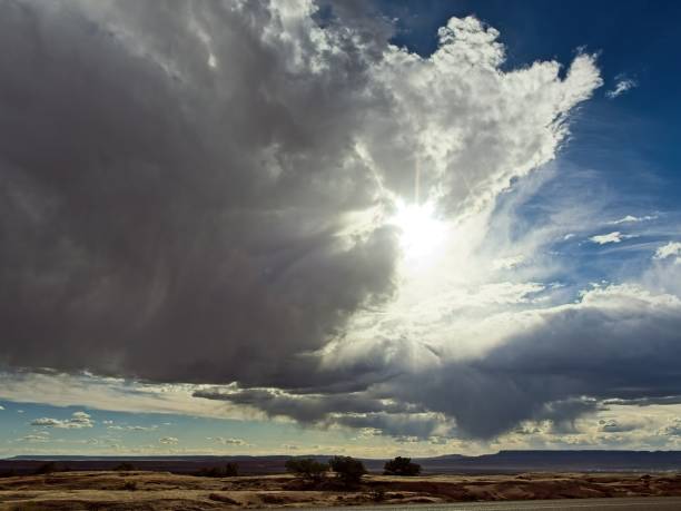 Rain shower develops over arid landscape over northeast Arizona near Chinle. Dramatic moody cloudscape with rain shower not quite reaching the ground (virga) near the arid lands of Canyon de Chelly.