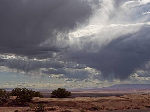 Rain shower develops over arid landscape over northeast Arizona near Chinle. Dramatic moody cloudscape with rain shower not quite reaching the ground (virga) near the arid lands of Canyon de Chelly.