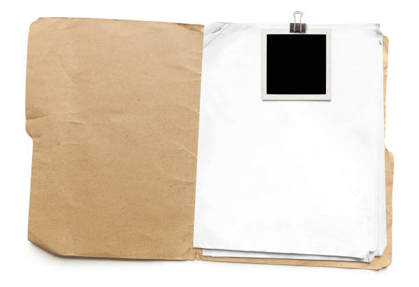 Old Manila Folder Old run-down manila folder with papers and attached photo isolated on white background manila folder and paper clip stock pictures, royalty-free photos & images
