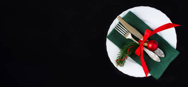 istock Christmas table setting with green napkin on the black background. Copy space. Top view. 2163276030