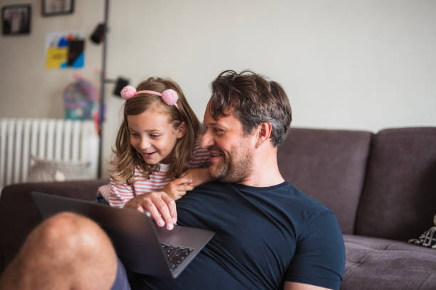 istock Father and daughter looking at laptop and laughing 2163276916