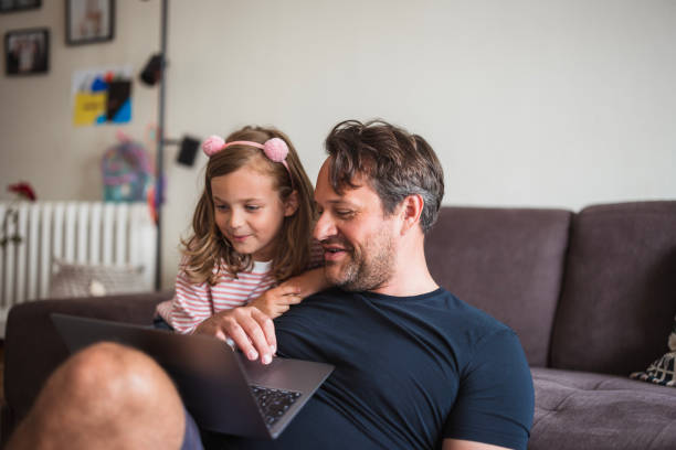 Father and daughter looking at laptop and laughing