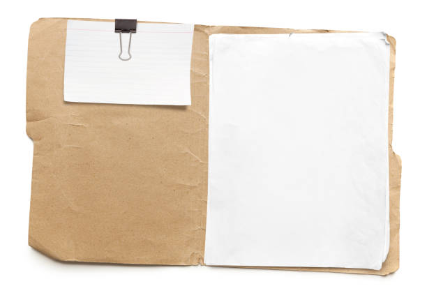 Old Manila Folder Old run-down manila folder with papers and attached index card isolated on white background manila folder and paper clip stock pictures, royalty-free photos & images