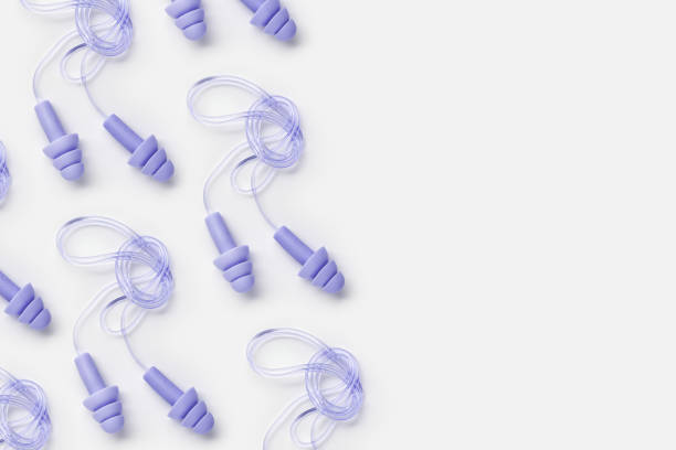 istock Creative flat lay pattern made purple silicone earplugs for swim, sleep, rest on white background. Comfort ear plug on string against noise, protect hear, top view, visual trends concept 2163281544