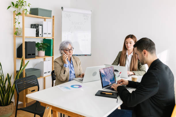 istock Coworkers sitting in the same table in a meeting room 2163282284