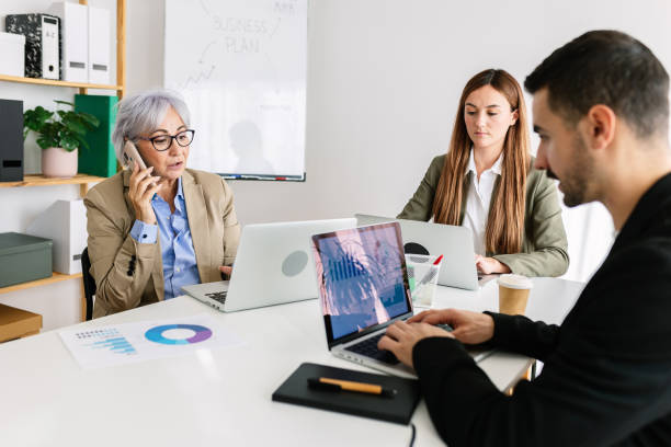 istock Diverse group of busy people working together in an office 2163282465