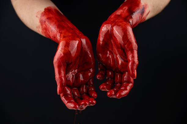 istock Women's hands in blood on a black background. 2163288334