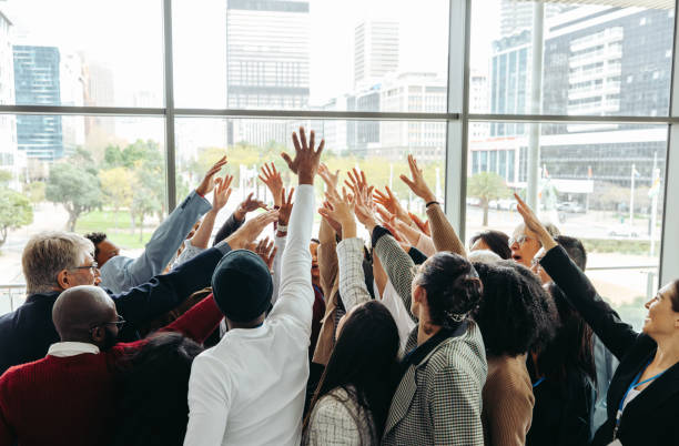 istock Celebrating teamwork: Diverse professionals huddling in a modern office 2163292785