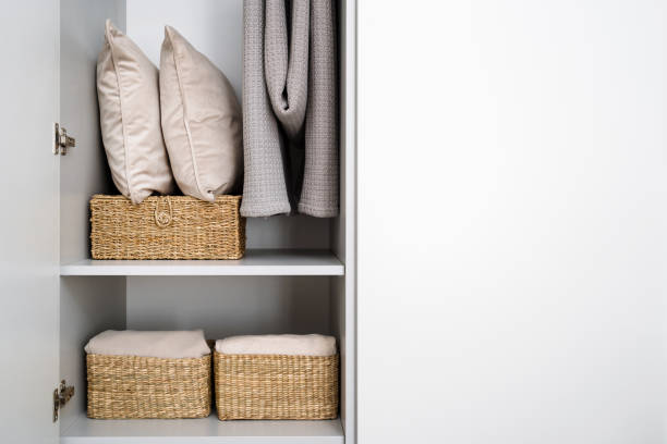 istock White closet with wicker baskets, pillows, blankets and plaids 2163299919