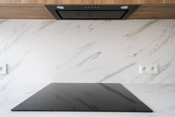 istock Modern kitchen countertop with black stovetop and range hood 2163300019