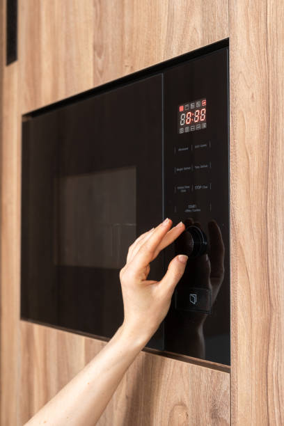 istock Hand adjusting microwave timer, heating of food at home 2163300037