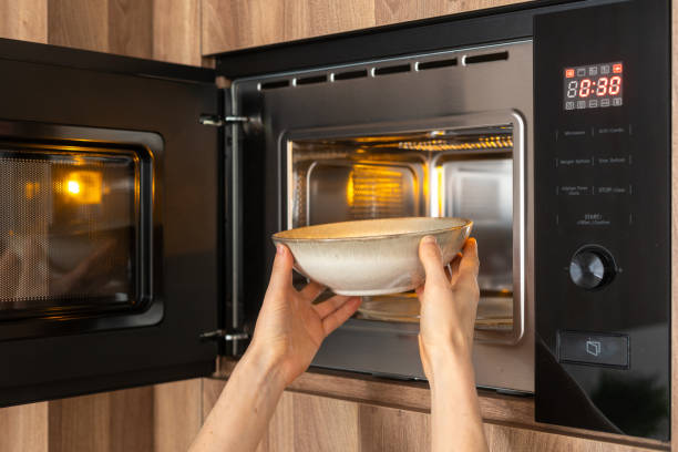 istock Person placing bowl with soup into microwave oven 2163300084